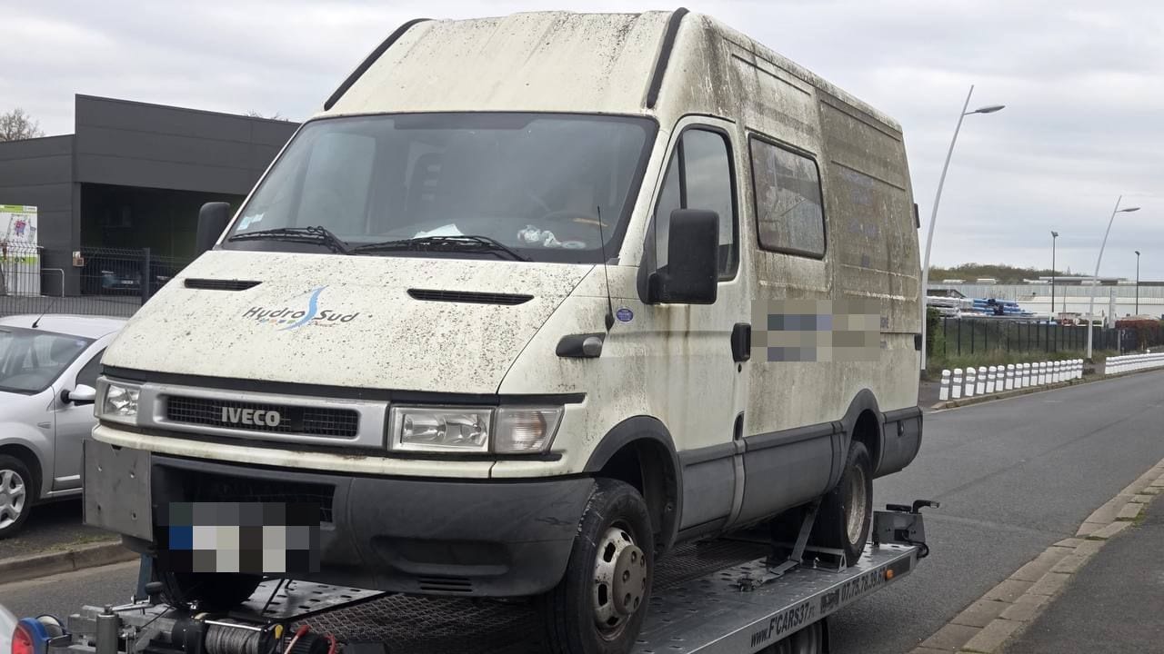 Fourgon Iveco Daily longtemps immobilisé, treuillé sur une remorque plateau en bord de route