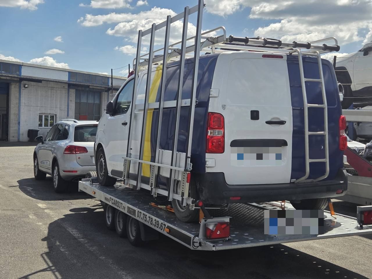 Fourgon Peugeot Expert avec galerie de toit arrimé sur une remorque plateau